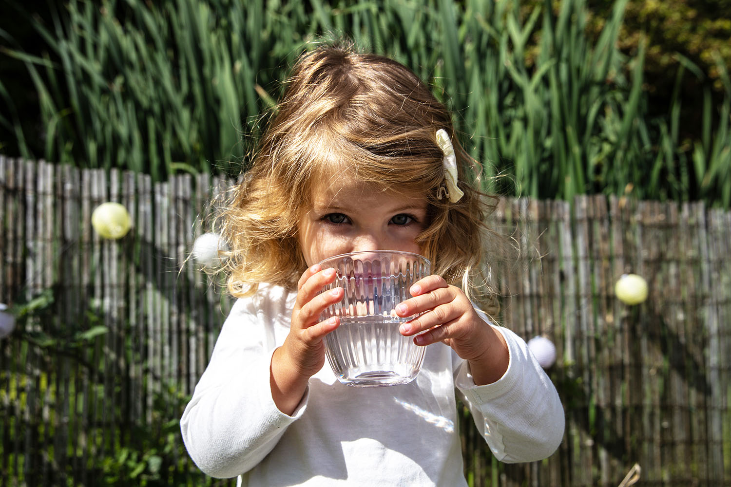 petite fille boit verre eau regard espiegle.jpg
